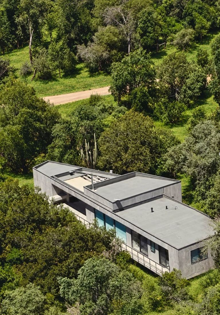 Vista aérea de una casa rodeada de bosque nativo en Parque Cantillana